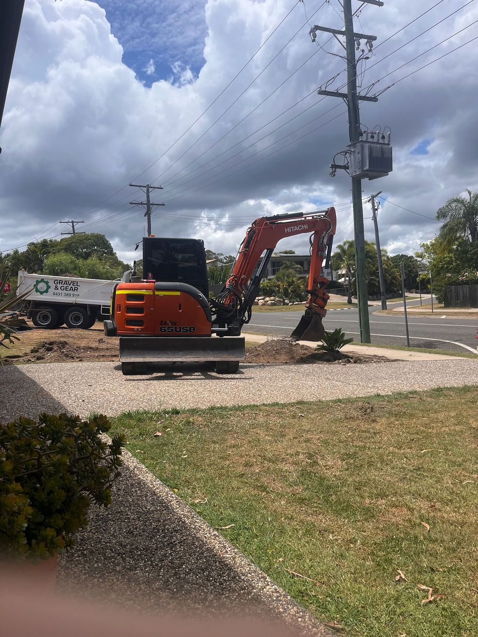 An orange excavator and a white truck for green waste removal.