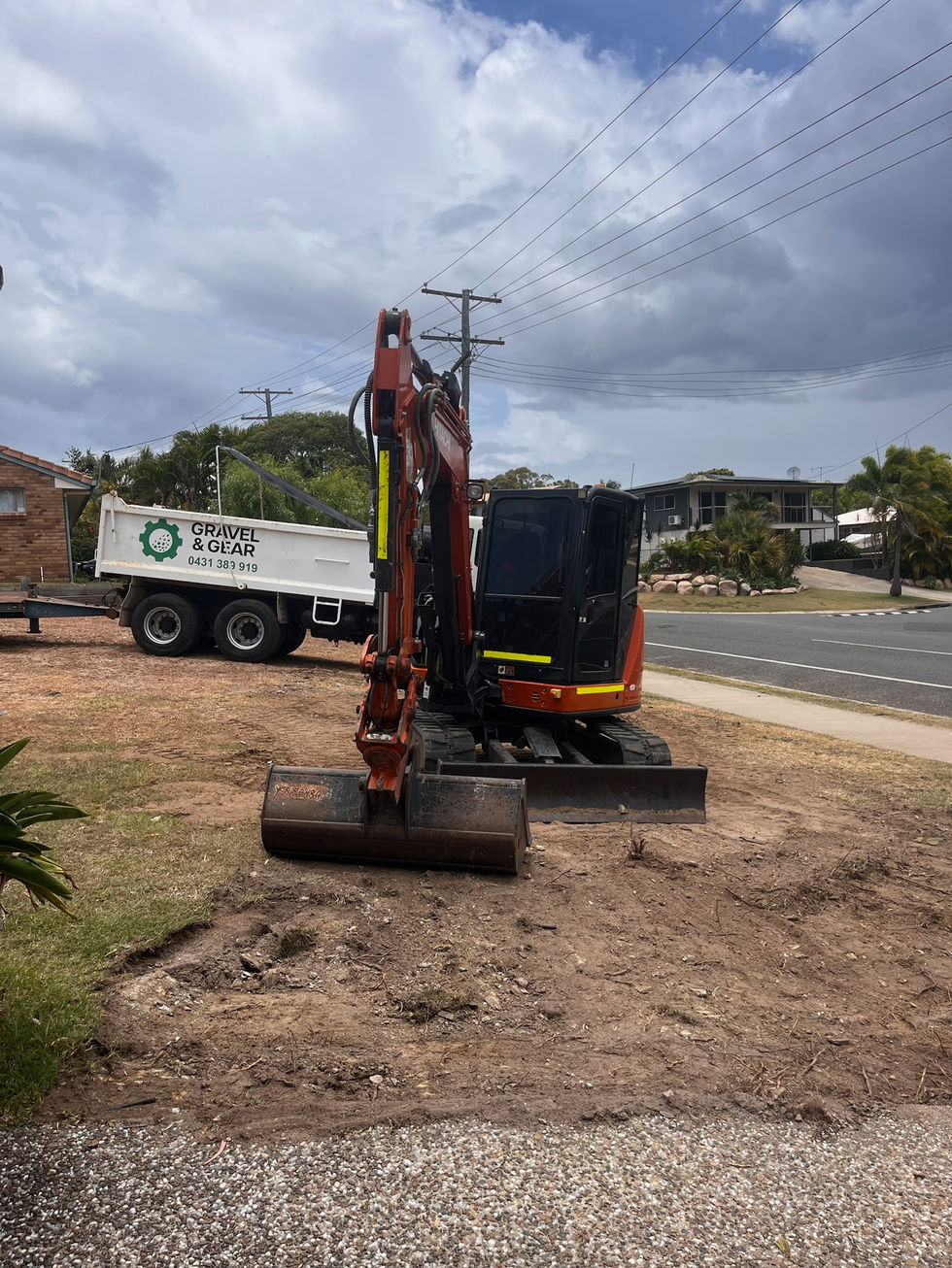 Small excavator and trailer on a dirt patch