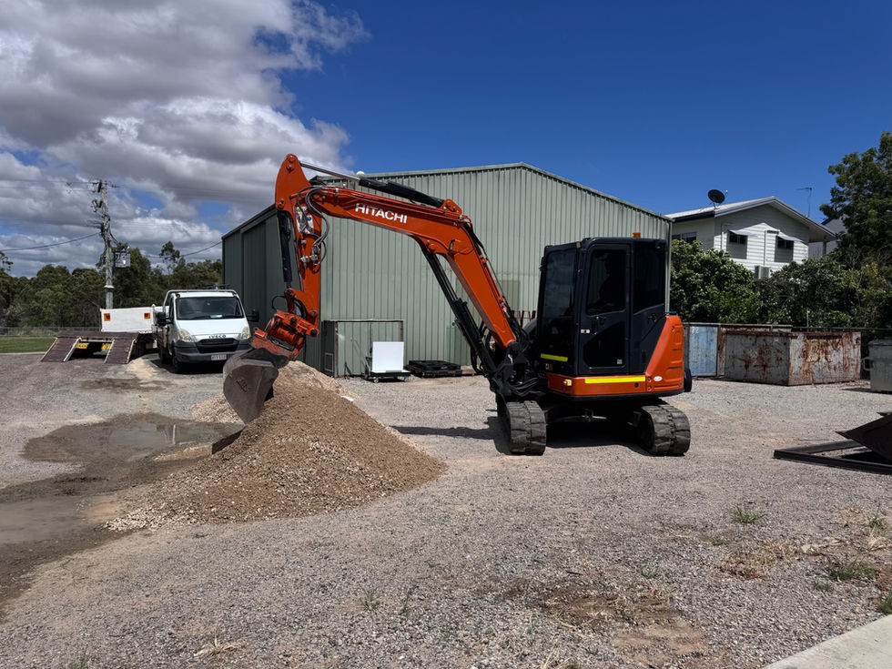 Orange Hitachi mini-excavator digging gravel