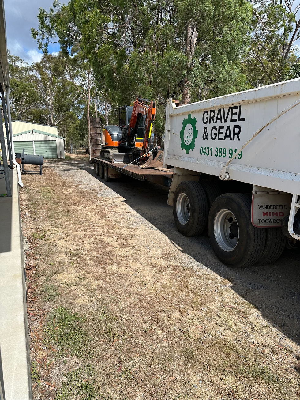 White Gravel & Gear truck with excavator on trailer