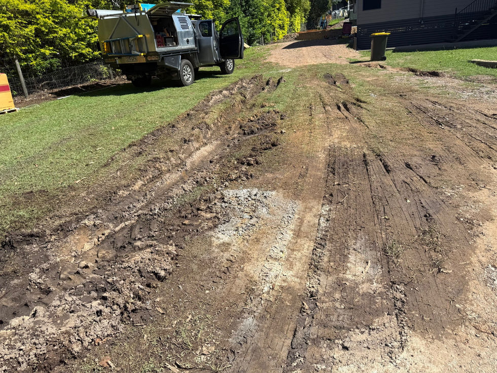 Muddy site with deep tire tracks and a utility truck