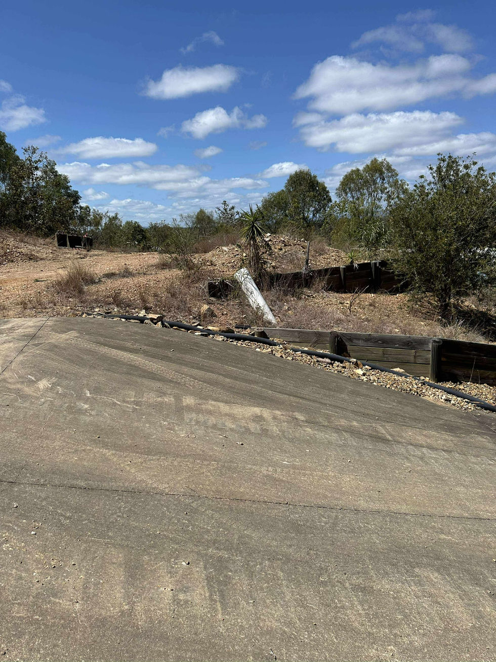 Dirt track with tire barriers under a blue sky