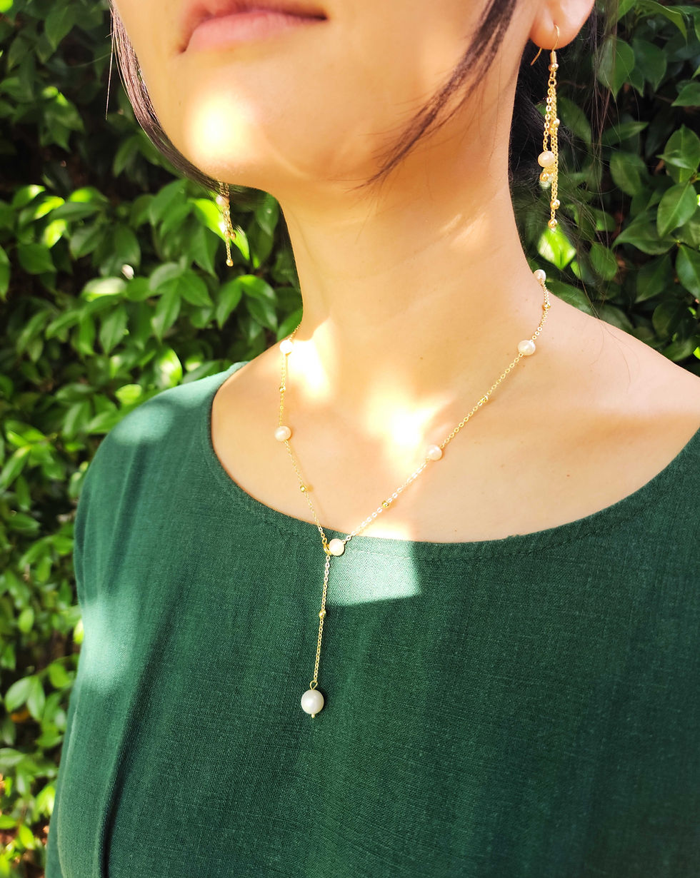Thumbnail: woman in green dress wearing elegant pearl necklace and earrings