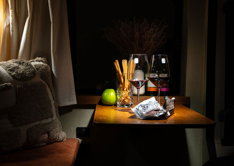 Glāzes ar vīnu, uzkodas un ābols uz galda. avantour.lv luksus kempers