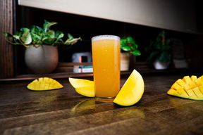 Beverage product photography of a mango drink styled with fresh mango slices photographed in Tampa Bay by LubaLand