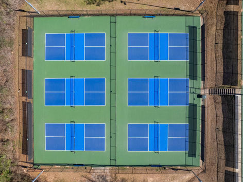 Top-down view of multiple pickleball courts with new surface and striping in Auburn, AL