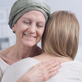 Smiling cancer woman embracing young gir