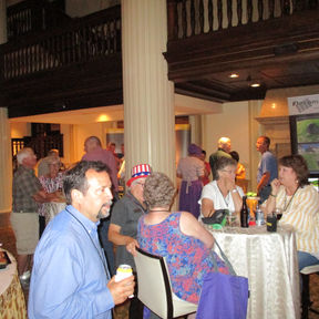 Group of people sitting at round tables in a banquet hall.