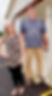 A woman in a leopard shirt and black pants standing next to a man in a blue shirt with khaki pants.