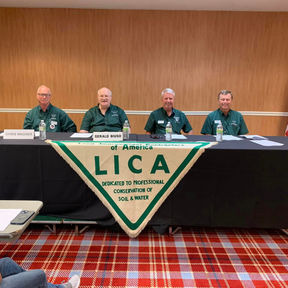 4 men at a long black table