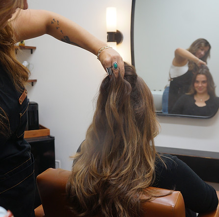 Hair stylist styling hair after color service