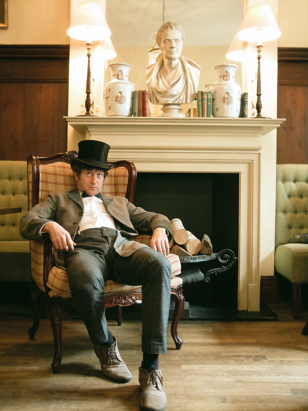 Ian Chapman in top hat and dinner attire slouching in chair deep in thought