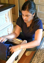 Professional organizer Dianne Collins arranging vertical folded pants into a dresser drawer