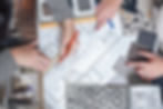 Corporate event designer planning with floor plans and fabric swatches.