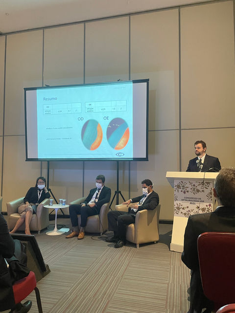 Dr. Lucca Ortolan Hansen lecionando no Congresso da Universidade de São Paulo na Sessão de Cirurgia Refrativa sobre um caso de LASIK. O Dr. Lucca está apresentando o caso para os demais congressistas.