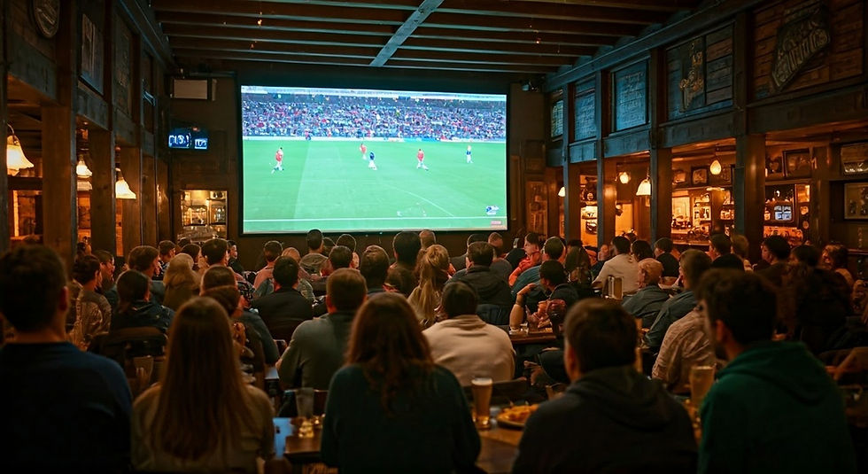 Crowded pub with fans watching a soccer match on a huge screen, warm wood interior and bright green field on TV.