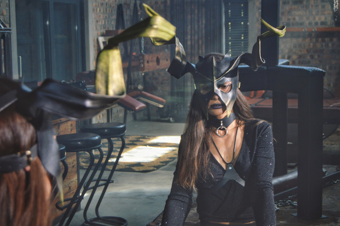 Masked person in black, adult playroom discipline photography
