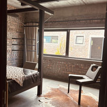 Industrial-style bedroom with four-poster bed