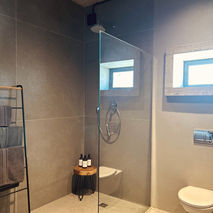 Modern glass shower with toilet and towels