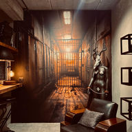 Dramatic prison corridor mural, leather armchair, goat statue