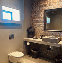 Modern bathroom with brick wall, sink, and toilet
