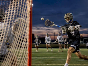 Lacrosse player shooting during competitive game