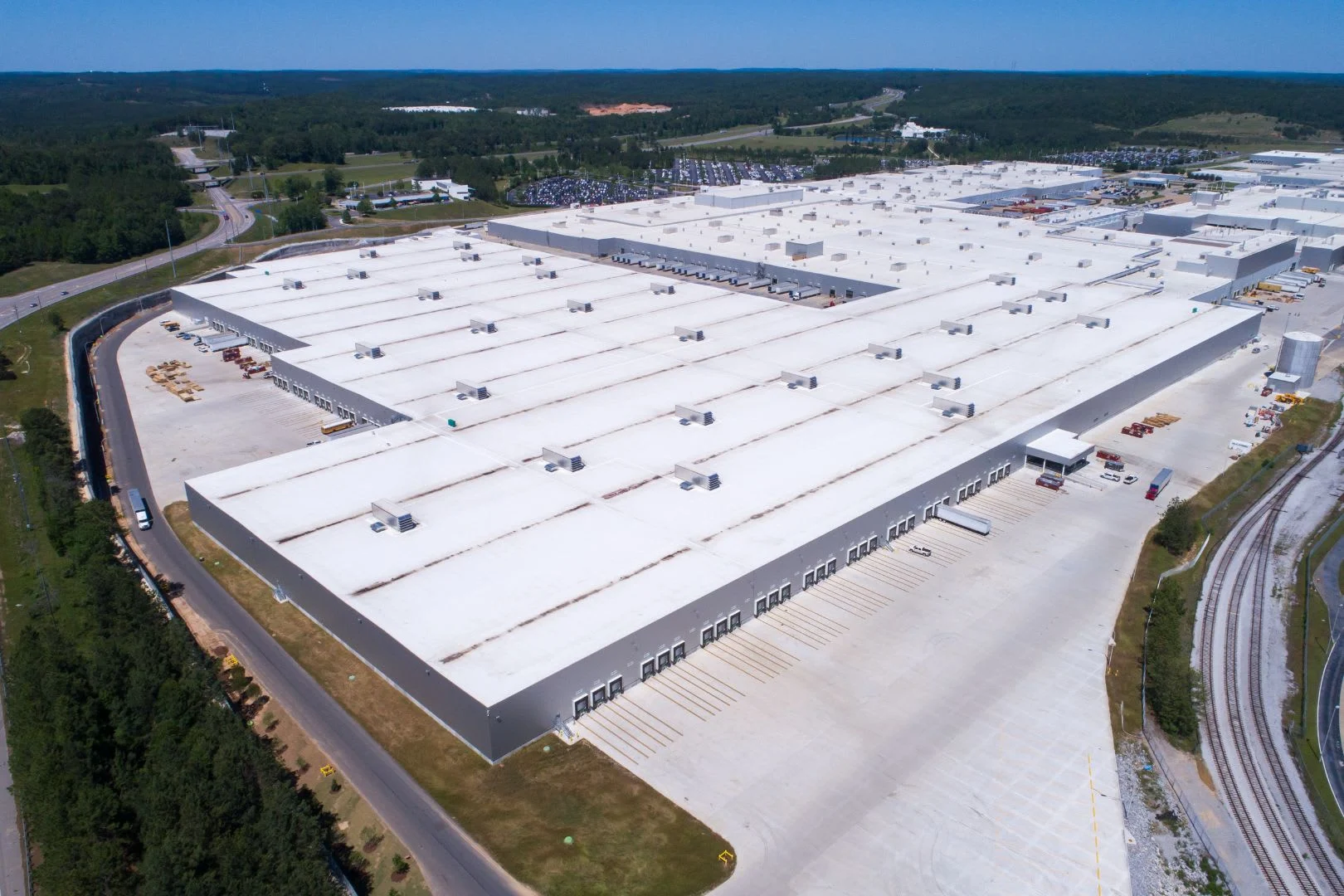 Close-up view of a TPO roofing system on a commercial building, featuring white reflective membrane and heat-welded seams