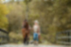 cowgirl walking her horse across a bridge