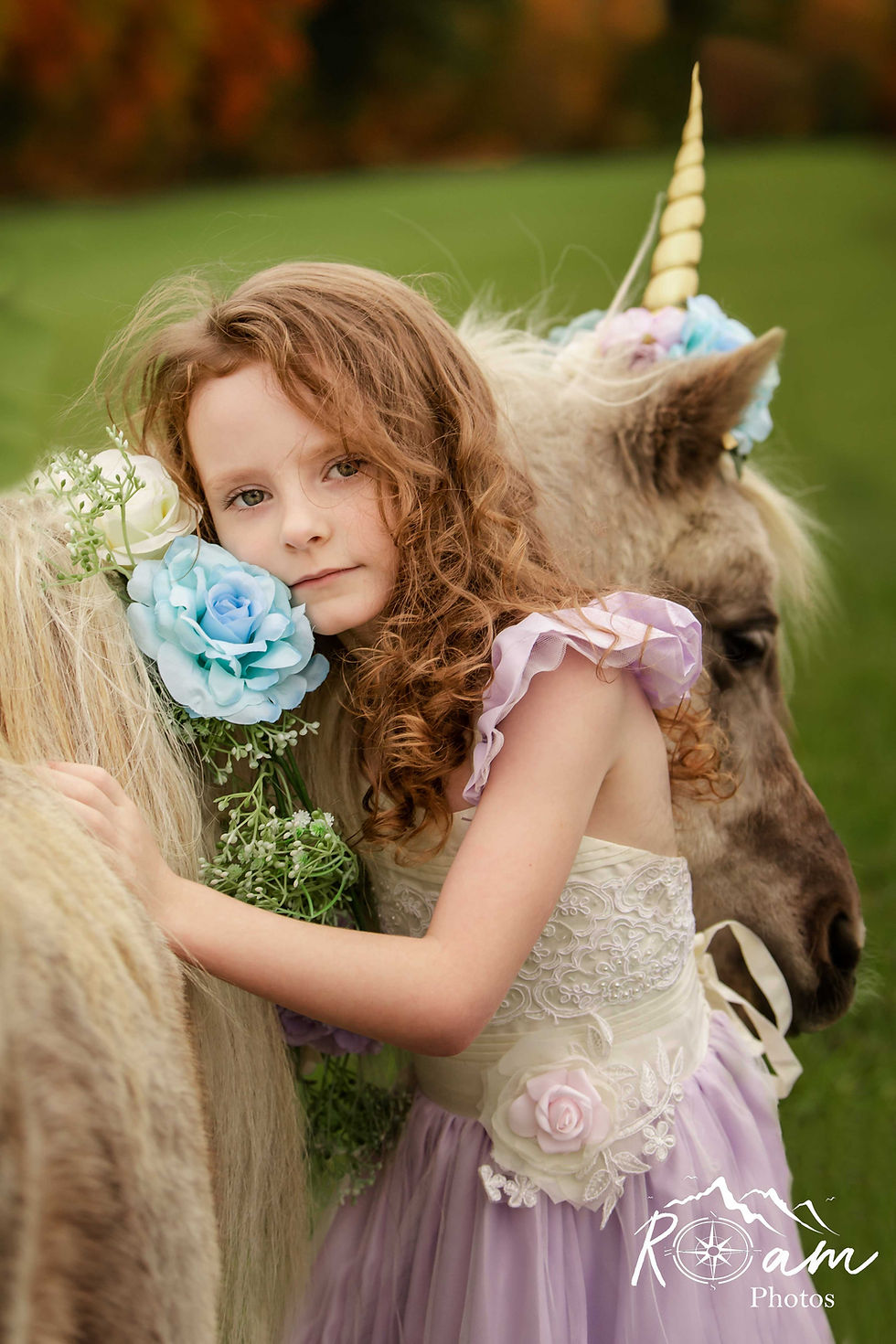 Little red headed girl hugging a unicorn pony