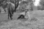 Cowgirl sitting in grass with horse.
