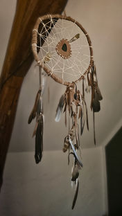 Handcrafted dreamcatcher made from willow branch, recycled leather, semi-precious stones, and feathers gathered in the forest, created intuitively.