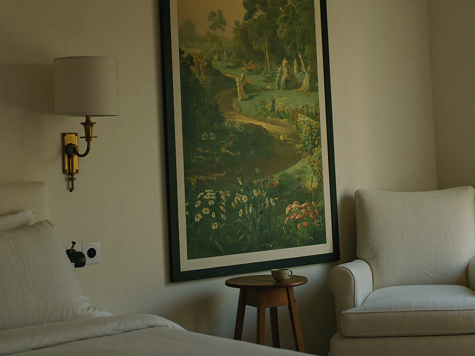 Pastoral landscape wall art beside a linen reading chair in a quiet bedroom corner.
