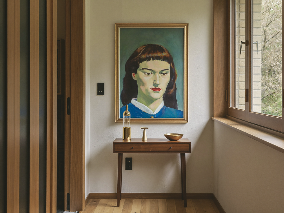 Vertical portrait painting in a narrow hallway above a console
