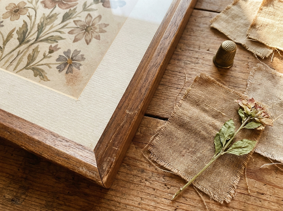Close-up of vintage floral art, cream mat, walnut frame, linen, and brass styling samples