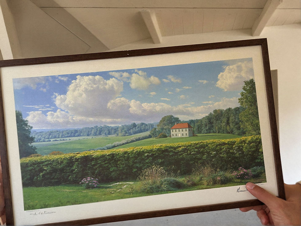 Close view of matte pastoral landscape art with a clouded sky and distant farmhouse.