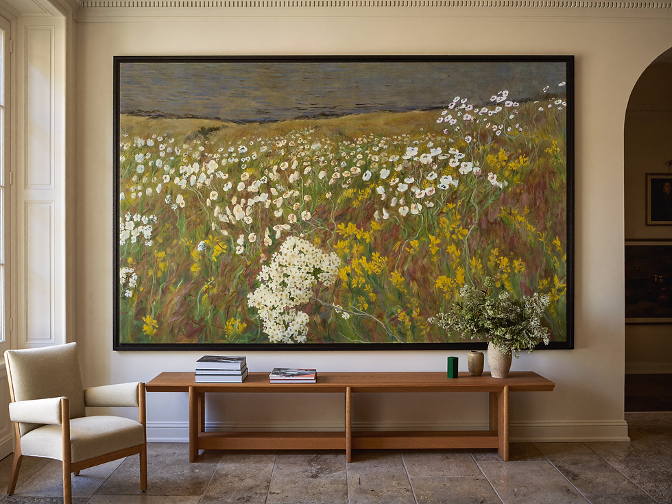 Monumental framed wildflower meadow painting above a low oak console in a refined interior.