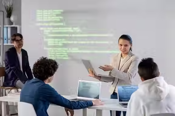 young-successful-businesswoman-pointing-laptop-display-while-explaining-data-colleagues-pr