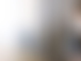 Comptoir hôtelier en perspective avec au premier plan un cloche et dans le fond une hôtesse d'accueil qui consulte un ordinateur