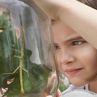 Child in nature playing with leaves