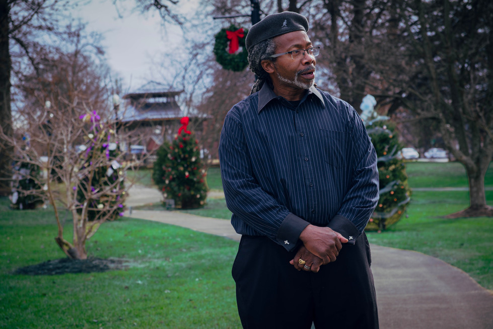 Blackman posing face turned slightly right, one hand over the other 