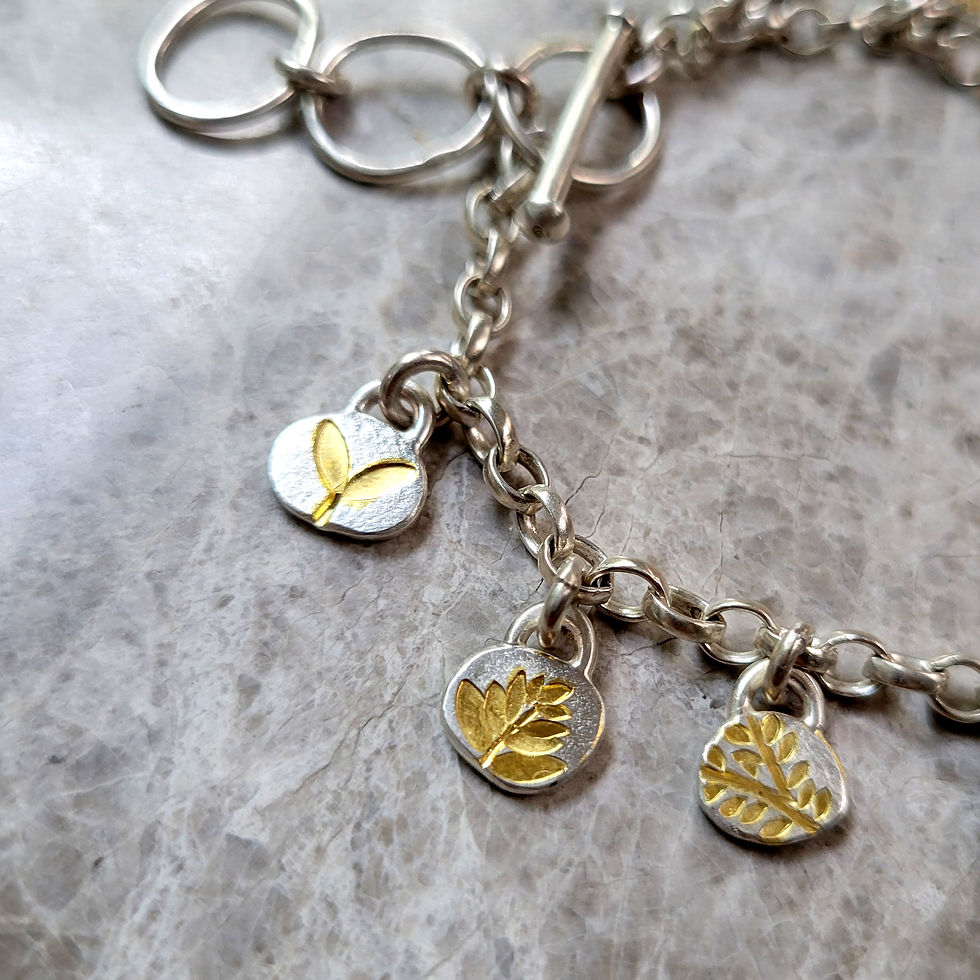 Thumbnail: Small solid silver and gold charm bracelet made in britain
