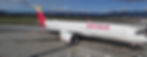 Iberia jet parked on an airport tarmac with mountains in the background and clear blue sky.