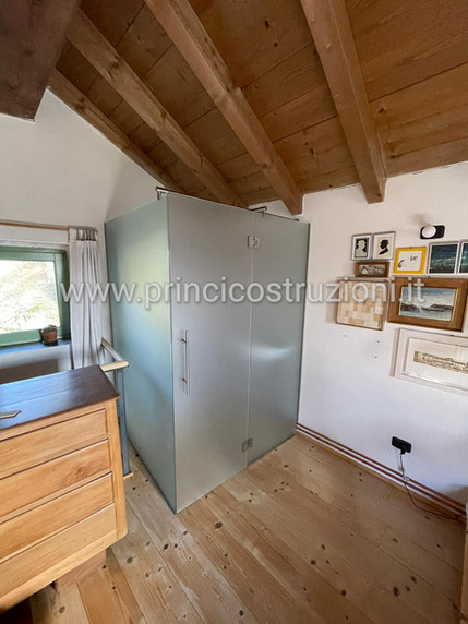 mansarda pavimento legno e zona sanitari in vetro satinato