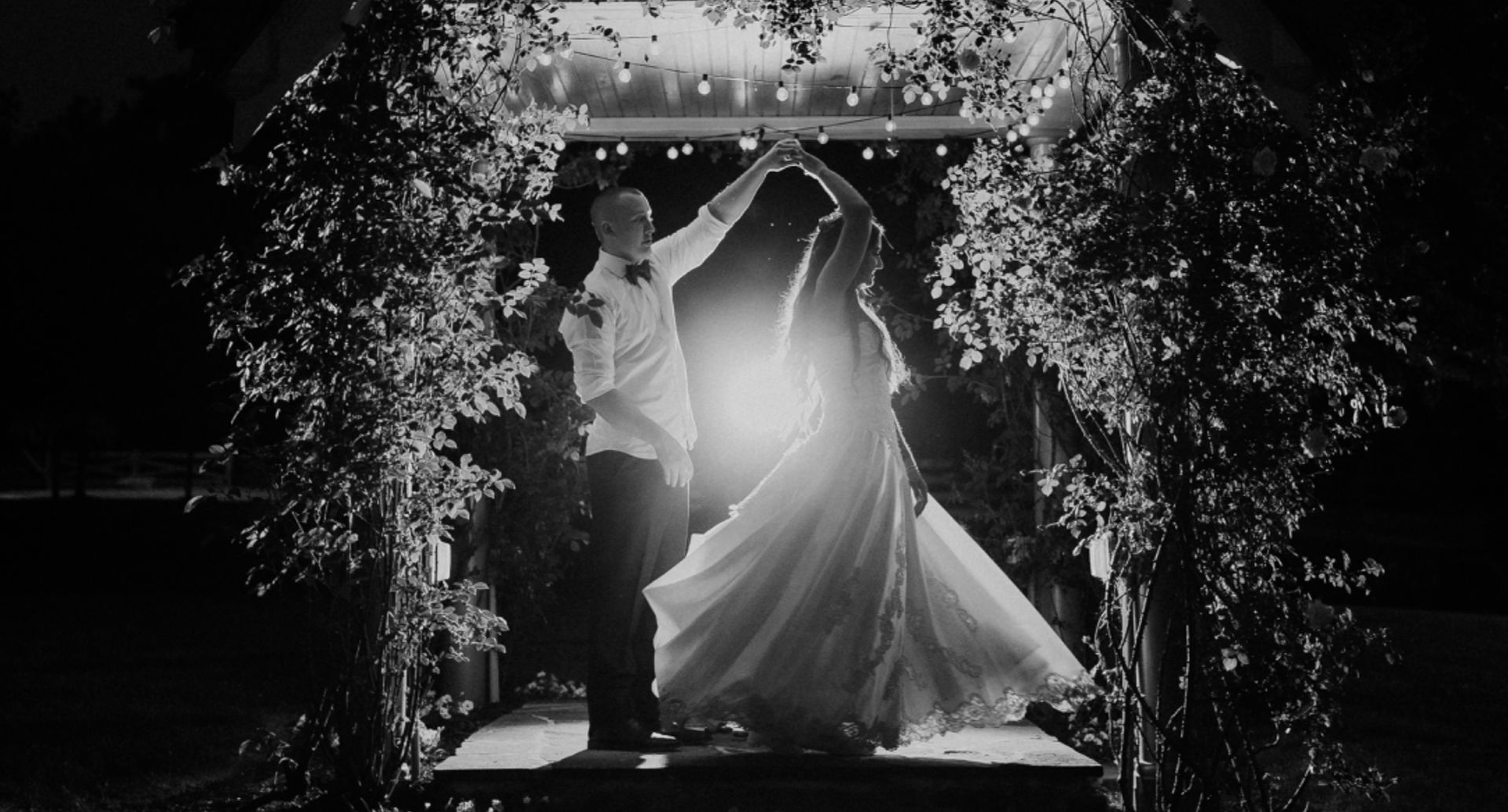 Deo and Kane share a romantic dance under a softly lit archway at night, beautifully captured by Rosenberry Media at Moonstone Manor.