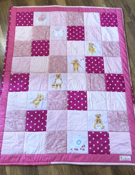 An enlarged image of the Teddy Bear Picnic Quilt in a light pink color scheme, adding a soft and gentle touch to its design.