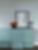 Flowers and a frame on a sideboard
