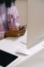 Team member sitting at her desk on her phone