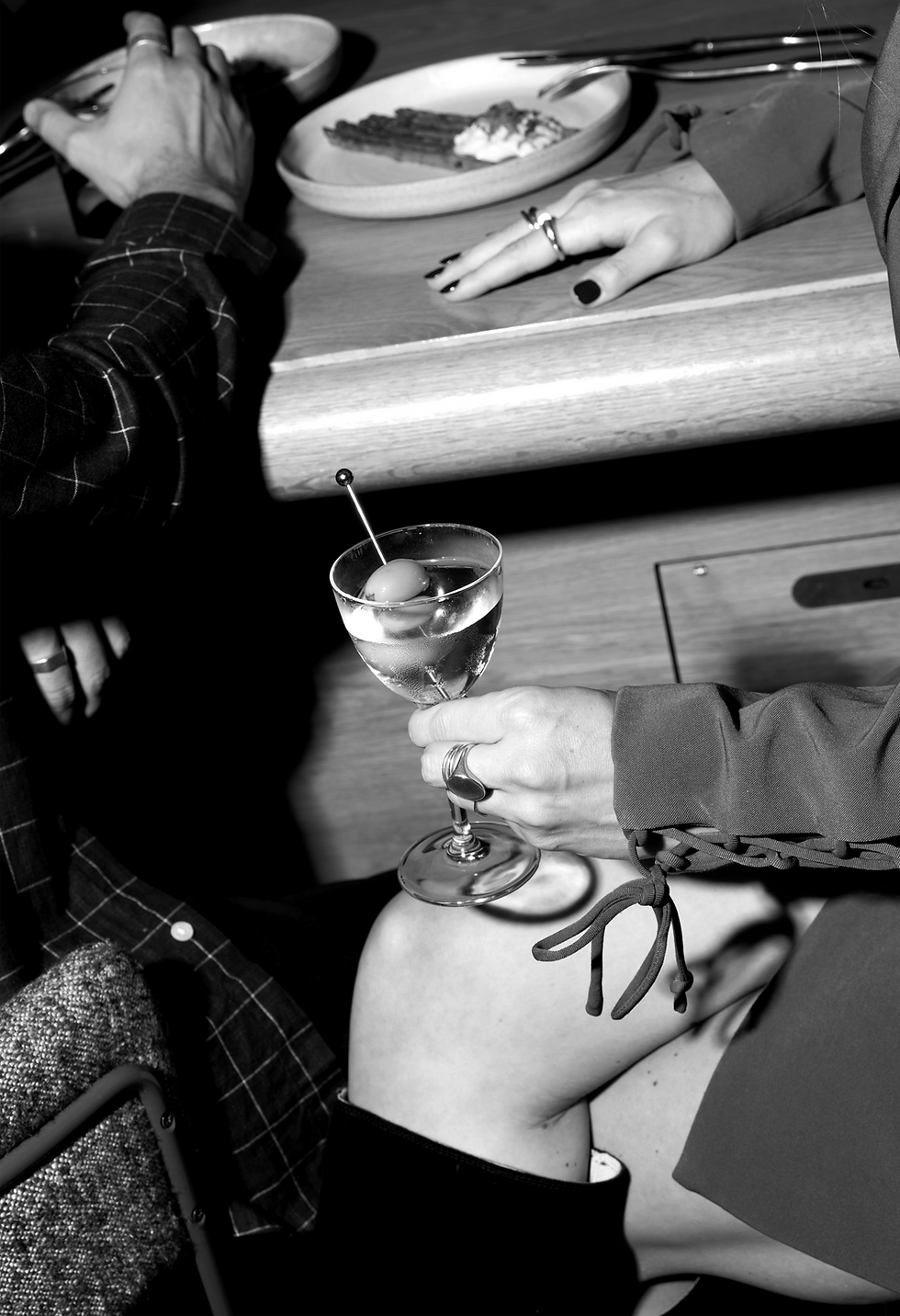 People seated at the bar at Bistro X holding a cocktail