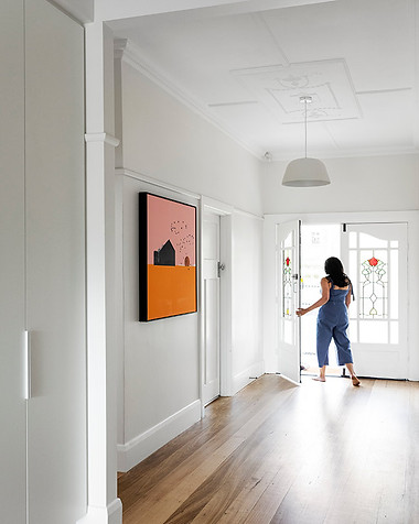 Interior entrance of newly renovated period home, woman opens front door