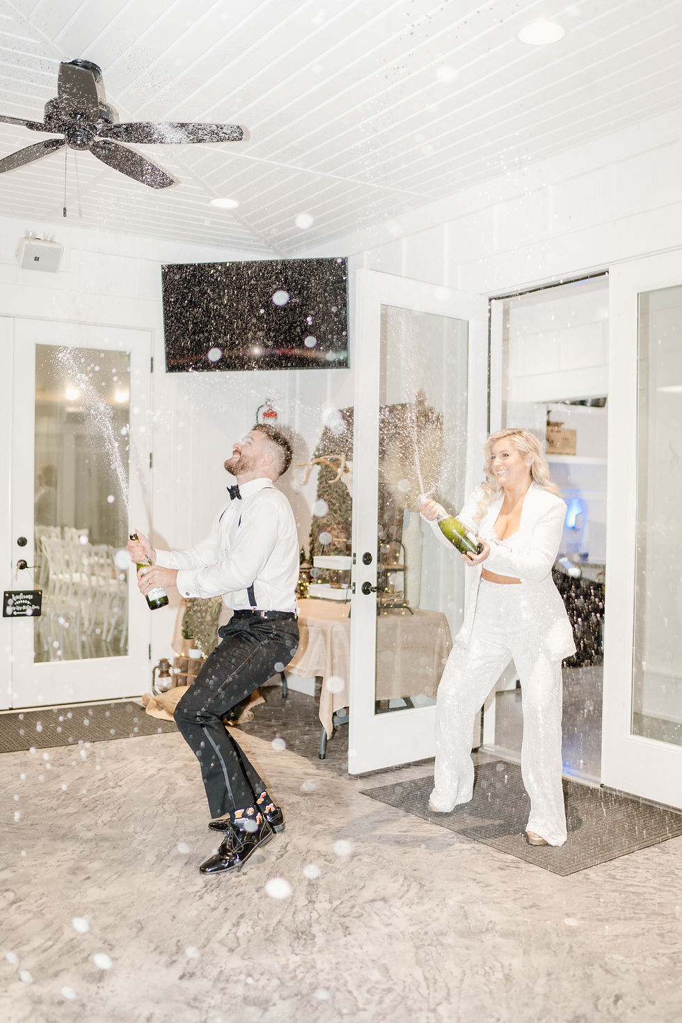 bride and groom popping champagne bottles